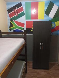 马塞约Hostel Morais Praia的客房设有一张床和挂有旗帜的橱柜。