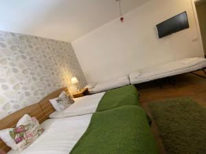 哈诺桑德城市酒店的卧室配有一张床,墙上配有电视。
