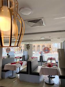 马斯喀特萨沃伊格兰特公寓式酒店的一间带桌椅和吊灯的餐厅