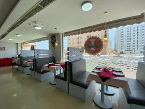 马斯喀特萨沃伊格兰特公寓式酒店的餐厅设有桌椅和大窗户。