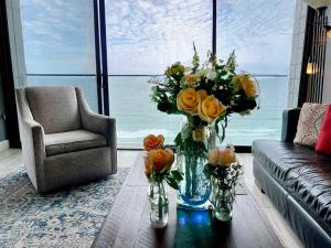 圣地亚哥Ocean View Luxury Condo Oceanfront and Pool的客厅,桌子上放着花瓶