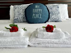 圣地亚哥Ocean View Luxury Condo Oceanfront and Pool的床上的两条毛巾,带玫瑰,枕头价格优惠