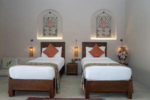 豪尔费坎Nozol Al Rayaheen By Sharjah Collection的带2扇窗户的客房内的2张床