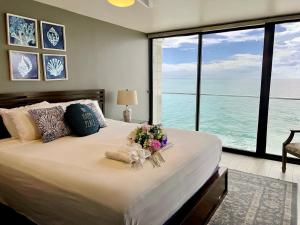 圣地亚哥Ocean View Luxury Condo Oceanfront and Pool的一间卧室配有一张带鲜花的大床