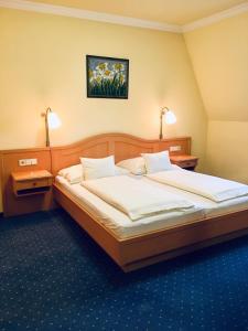 莫尔Hétkúti Wellness Hotel的一间卧室配有两张床和两盏灯。
