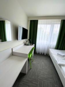 什切青Jantar Resort的酒店客房设有书桌和窗户。