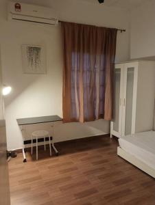 加影Tenang Retreat Holiday Home的一间卧室配有书桌、床和窗户。