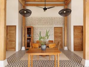 DalungSpaces Bali的一间带木桌和椅子的用餐室