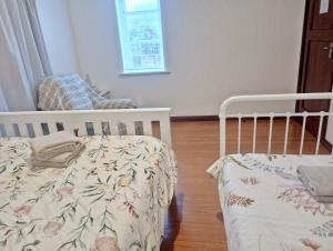 汉密尔顿Little Gem - City Centre的一间卧室配有婴儿床和椅子