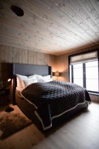斯特兰达Strandafjellet Panorama Lodge - Large Cabin with Majestic Mountain View的一间卧室设有一张带木制天花板的大床