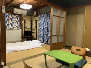熊野市瓦家兰奇旅馆的配有床和绿桌的客房