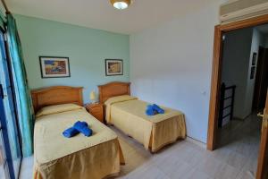 LajitaEl encanto的一间卧室配有两张带蓝色弓的床铺。
