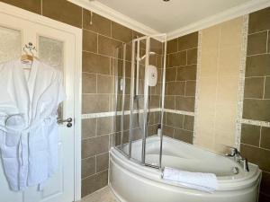 葛特纳格林博基安吉斯旅馆的浴室配有浴缸、毛巾和淋浴