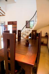 本托塔Villana Villa Bentota的一间带木桌和楼梯的用餐室