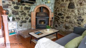 La Seronda de Villaorille - Las Casas del Oso的客厅设有石制壁炉和桌子。