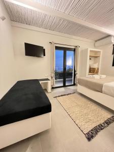 GanemaVie rêvée luxury suites的一间白色卧室,配有床和电视