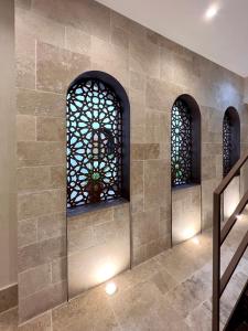 科尔多瓦Arcos de Medina - Apartamentos premium的石墙,两扇窗户和楼梯