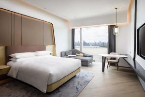 珠海珠海中海万丽酒店的卧室配有1张床、1张桌子和1把椅子