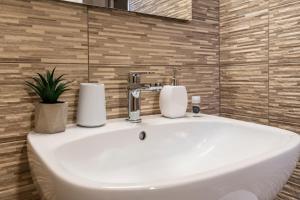 萨萨里Lumen House的白色浴室水槽和2条毛巾