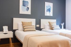 科巴罗Combarro Playa的蓝色墙壁客房的两张床
