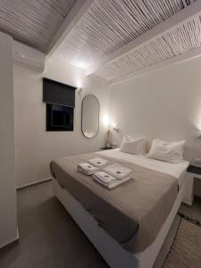 GanemaVie rêvée luxury suites的白色卧室,配有带毛巾的床