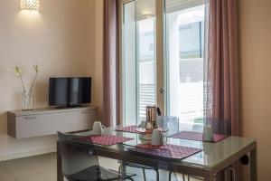 切塞纳蒂科Residence Millecento的客厅配有玻璃桌和电视