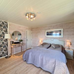 EidsvollVILLA HASSELBAKKEN的一间卧室配有一张床、一张桌子和一面镜子
