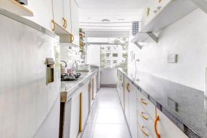 利马Green House的厨房设有白色的墙壁和黄色的橱柜
