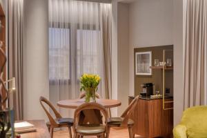 塞萨洛尼基塞萨洛尼基伊莱克特拉酒店的客厅里设有一张桌子,上面有花瓶