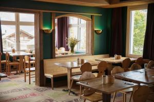米伦Hotel Drei Berge的餐厅设有木桌、椅子和镜子