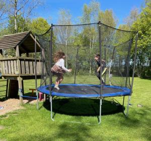 SchoonlooVeld lodge的两个孩子在院子里蹦床上玩耍