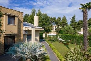 撒尼海滩Azalea Villa Sani, Sani Luxury Villas Collection的一个带吊床和房子的花园