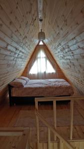 KireçhaneÇatalkaya Bungolov的木制客房的一张床位,设有窗户