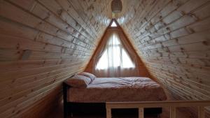KireçhaneÇatalkaya Bungolov的木制客房的一张小床,设有窗户