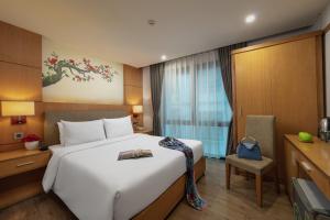 河内HALO HANOI HOTEL的酒店客房,配有床和电视