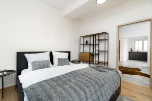 俄斯特拉发Beautiful Apartments With Parking In a Quiet Location的白色卧室设有一张大床和镜子