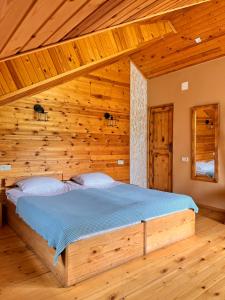 梅斯蒂亚Ioska's House的木制客房内的一间卧室,配有一张床