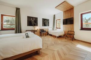 科尔蒂纳丹佩佐B&B Hotel Passo Tre Croci Cortina的酒店客房配有两张床和一张书桌