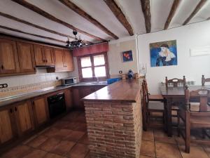 卡斯特里尔Casa Rural El Gandulillo的厨房配有木制橱柜和桌子。