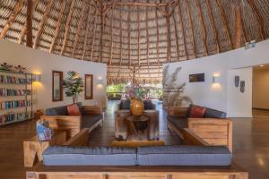 威廉斯塔德Morena Resort的带沙发和大型稻草屋顶的客厅