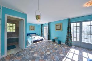 维耶尔宗L'Alhambra - Gîte Haut de Gamme的一间拥有蓝色墙壁的卧室,其中配有一张床