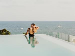 圣埃乌拉利亚Aguas de Ibiza Grand Luxe Hotel - Small Luxury Hotel of the World的坐在游泳池的水中的女人