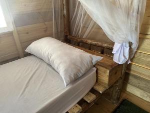 江比阿Coconuts Bandas的木平台上的一张带白色枕头的床