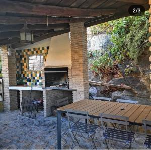 卡斯特里尔Casa Rural El Gandulillo的一个带桌子和砖炉的庭院
