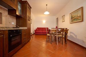 圣温琴佐Antichi Palmenti - Alloro的厨房以及带桌子和红色沙发的用餐室。