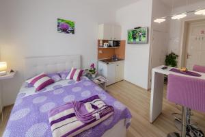 里耶卡Apartments Trend的一间带紫色床的卧室和一间厨房