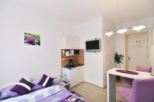 里耶卡Apartments Trend的一间带紫色沙发的客厅和一间厨房