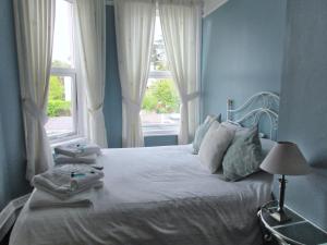 佩恩顿Birchwood House的蓝色卧室,配有带毛巾的床