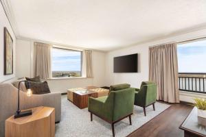 路易斯威尔高尔豪斯Trademark精选酒店的客厅配有沙发、椅子和电视