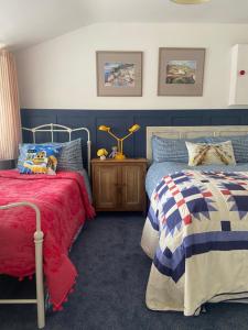 特拉利Barrow Harbour studio apartment的一间卧室设有两张床和一张带台灯的桌子。